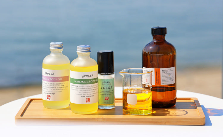 Massage oils, Sleep CBD oil, and essential oils on a bamboo tray